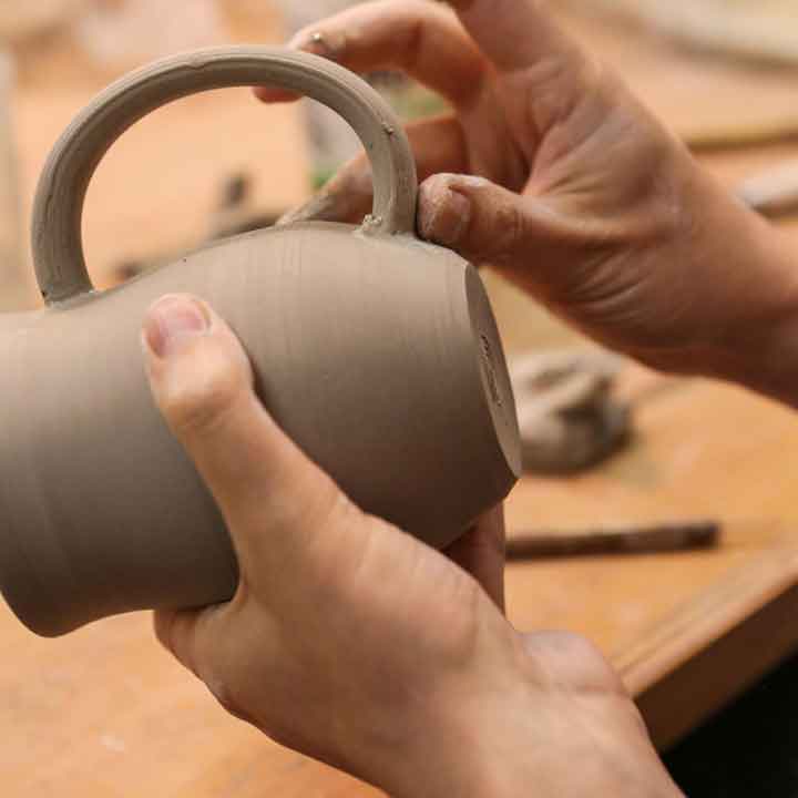 Image of a hand fixing a pot